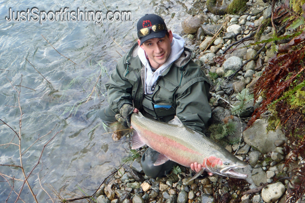 Photo of a fisherman holding a steelhead.